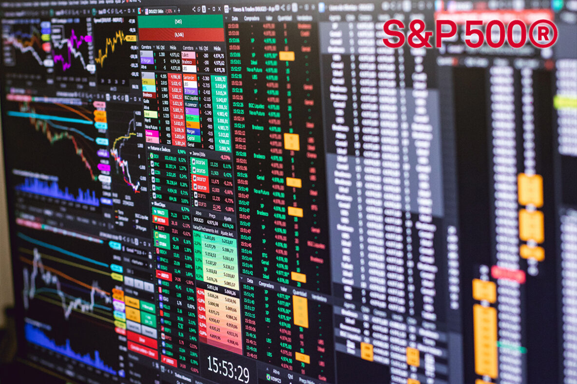 Stock market monitors displaying green and red trading numbers with the S&P 500 logo in top-right corner.
