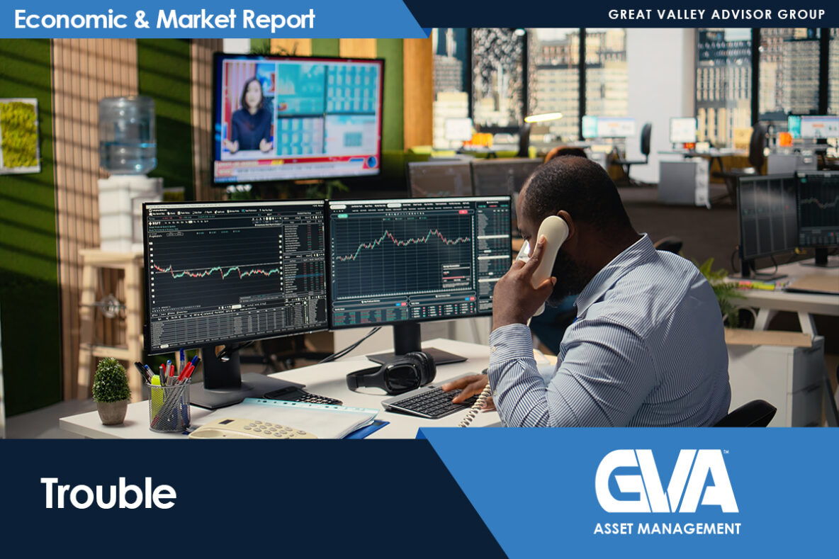 Trader at a desk with multiple monitors displaying stock charts for an Economic & Market Report banner.